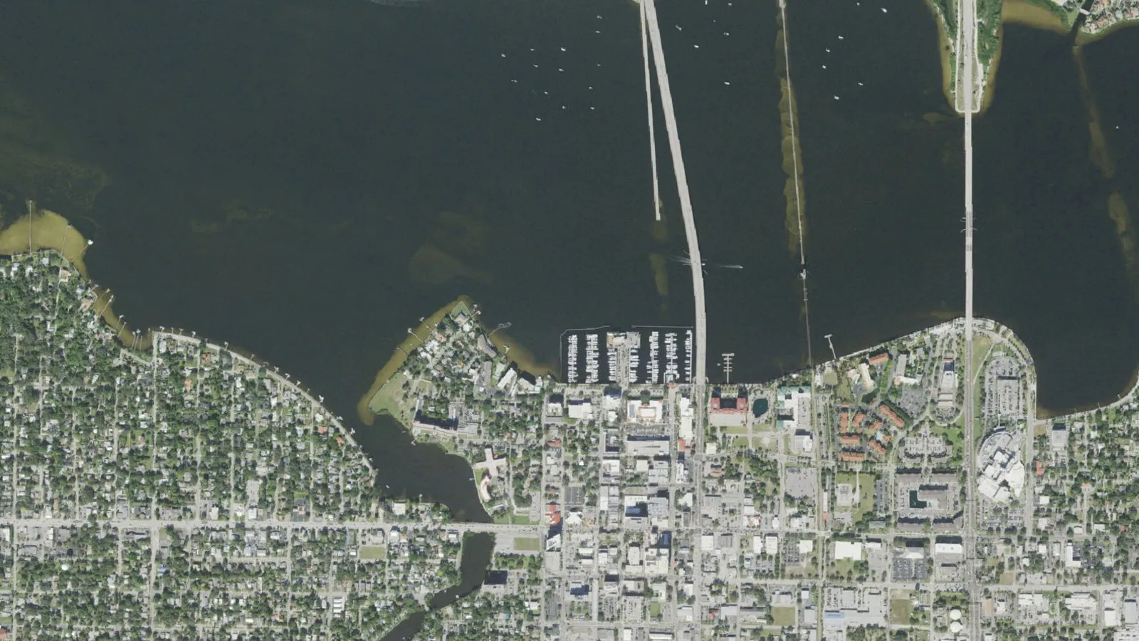 Aerial view of downtown Bradenton, FL along the Manatee River, with the bridges to Palmetto crossing the water