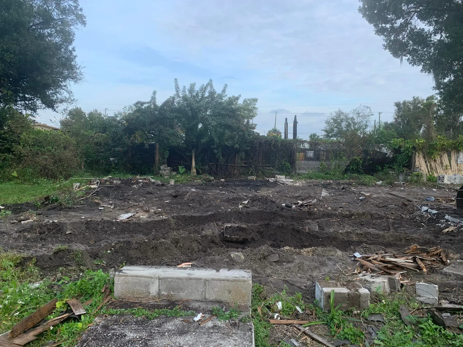 Footprint of a demolished house with block rubble being cleared